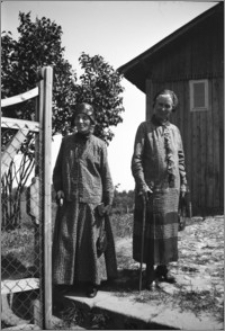 [Michalina Bereźnicka i Maria Bociarska stojące przed drewnianą kaplicą w Otłoczynie-Kucie